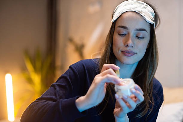 woman applying retinol cream at night showing correct evening skincare routine