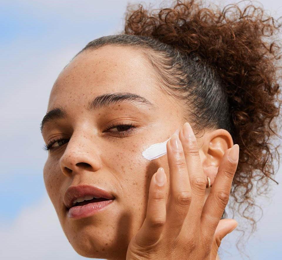 Applying lightweight sunscreen on acne-prone teenage skin