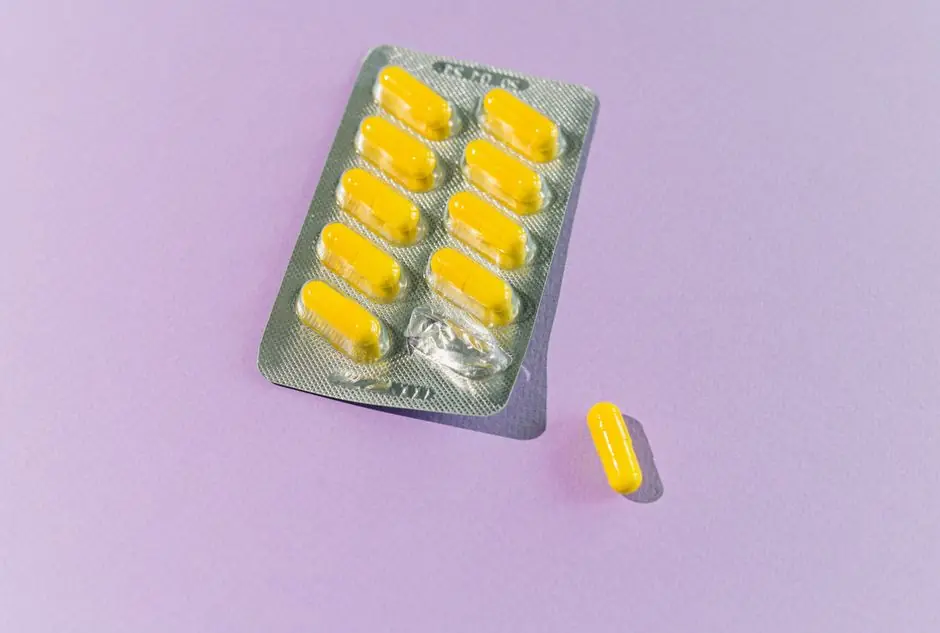 A blister pack of yellow capsules with one pill on a purple backdrop.